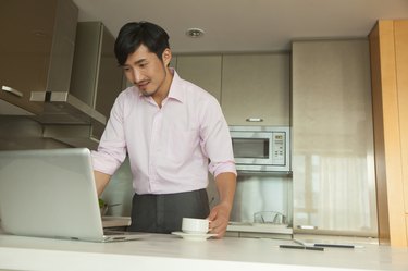 Businessman in front of his computer drinking coffee at home