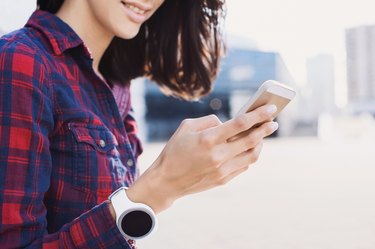 Girl wearing smartwatch using smart phone