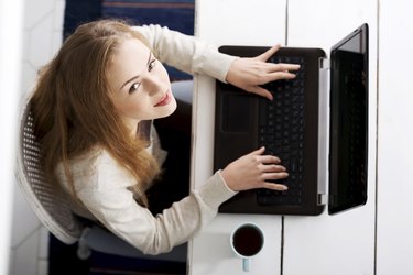 Beautiful caucasian woman sitting with hot drink and working on