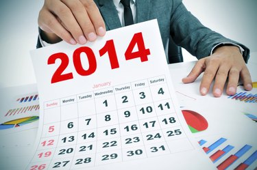 man in suit with charts and a 2014 calendar