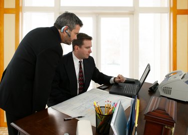 Two businessmen looking at a laptop