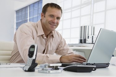 Smiling businessman using laptop