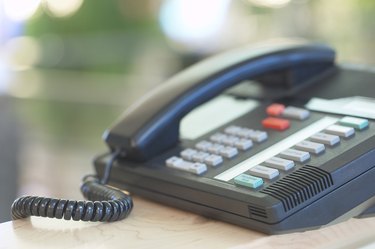 Business telephone with extensions on desk in office