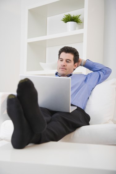 Mixed Race man looking at laptop