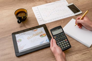 business concept - graph, calculator, tablet and pen on desk