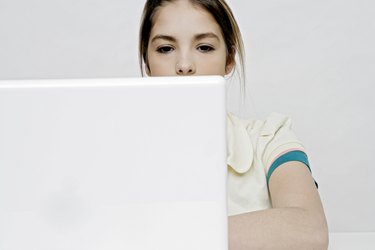 View of a teenage girl working with a laptop.