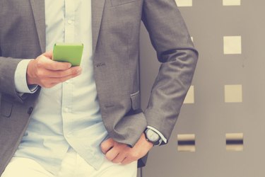 Elegant man using cellphone outdoors.