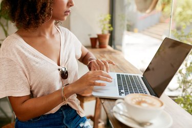 Young woman working on laptop in cafe