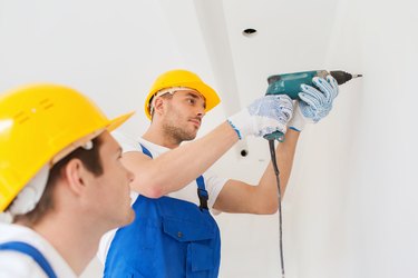 group of builders with drill indoors