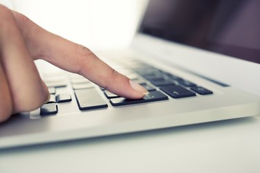 Female hand using computer keyboard, enter button