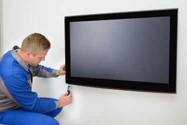 A repairman fixing a television