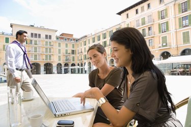 Businesswomen using laptop computer at outdoor cafe