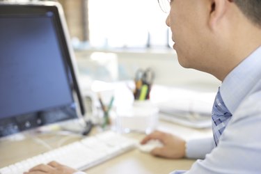 Shot in the UK, businessman wokring at computer