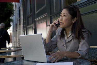 Businesswoman using laptop and mobile phone