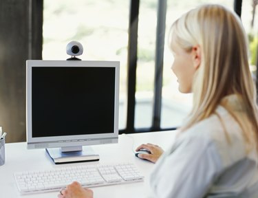 rear view of a mid adult woman using a computer