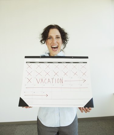 Businesswoman holding a calendar with her vacation marked on it