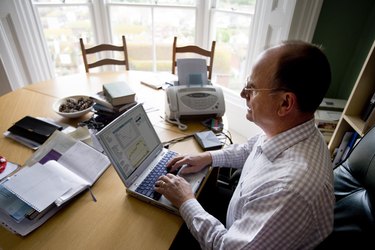 Man working on laptop at dining room table