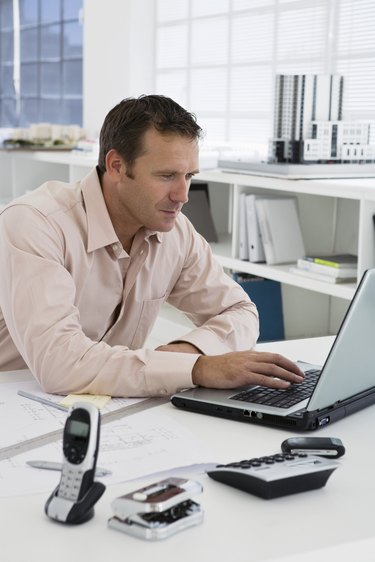 Smiling businessman using laptop