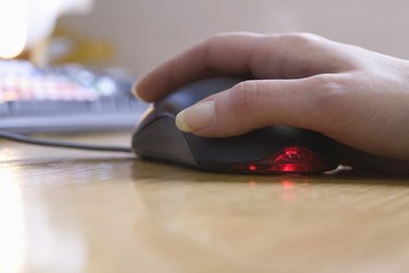 Hand touching computer mouse