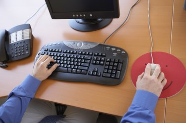 High angle view of a young man's hands working on a computer