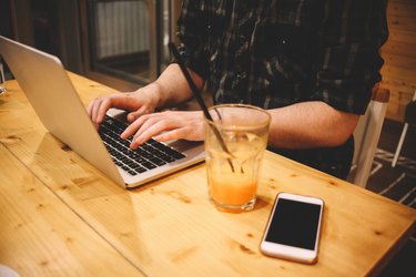 Young man sitting in a coffee shop using laptop