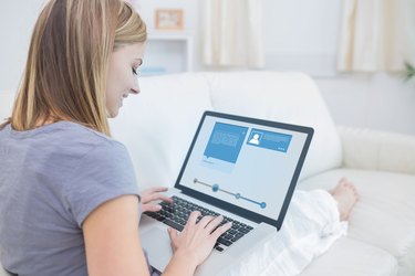 Woman sitting on sofa and checking her social media profile