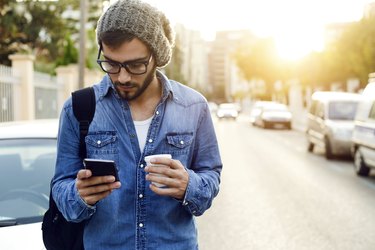 Modern young man with mobile phone in the street.