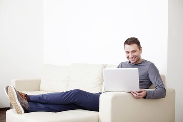 Man sitting on sofa with digital tablet
