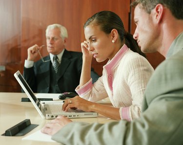 Businesswoman using laptop in boardroom meeting