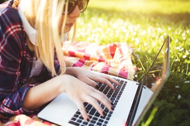 Attractive woman using laptop in the park