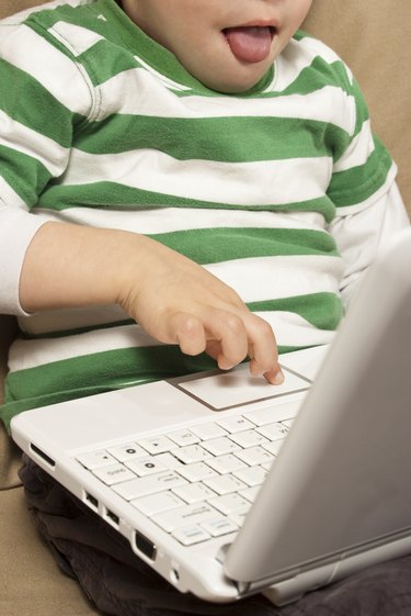 Young boy uses touchpad on Netbook computer