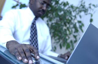 A mid adult businessman working on a laptop computer