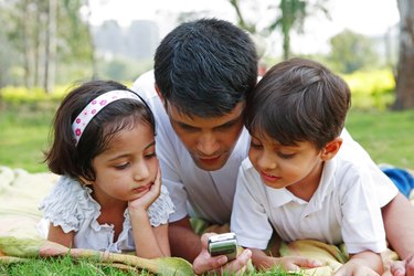 Father showing his mobile to his children