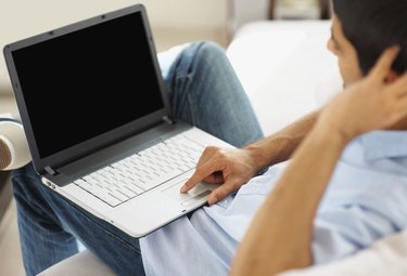 Closeup of guy working on a laptop indoor