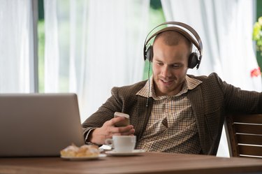 Young man listening to music with headphones at a cafe