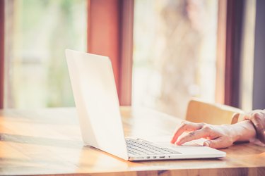 Hand woman typing key pad of laptop.