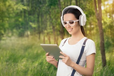 Girl with Headphones and a Tablet PC