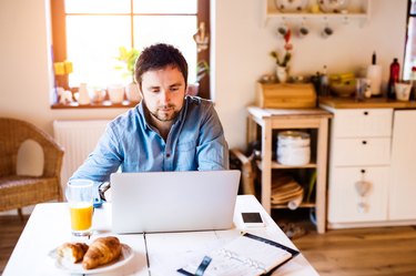 Man sitting at desk working from home on laptop
