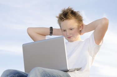 Fair-haired schoolboy relaxing hands behind his head