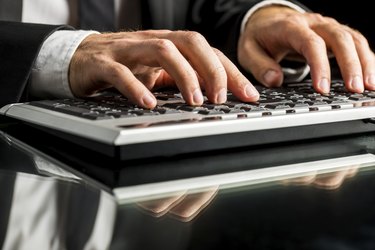 Businessman working on computer by typewriting