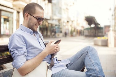 Young man using smartphone of street