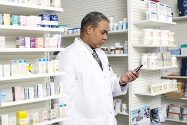 Pharmacist checking portable communication device