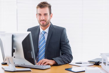 Young businessman using computer at office desk