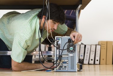 Man working on computer under desk