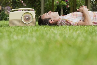 Man relaxing on lawn with old-fashioned radio