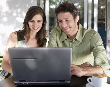 Couple using laptop computer in coffee shop