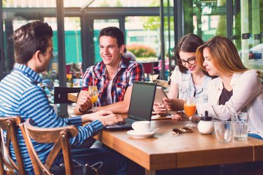 Group of young people sitting at a cafe, talking