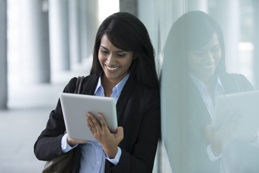 Young Indian businesswoman standing outside using Tablet PC