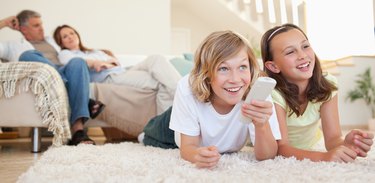 Siblings lying on the floor watching tv