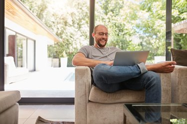 Happy mature man having video call on laptop